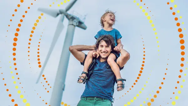 A man carrying his daughter on his shoulders - Sainsbury energy is 100% renewable